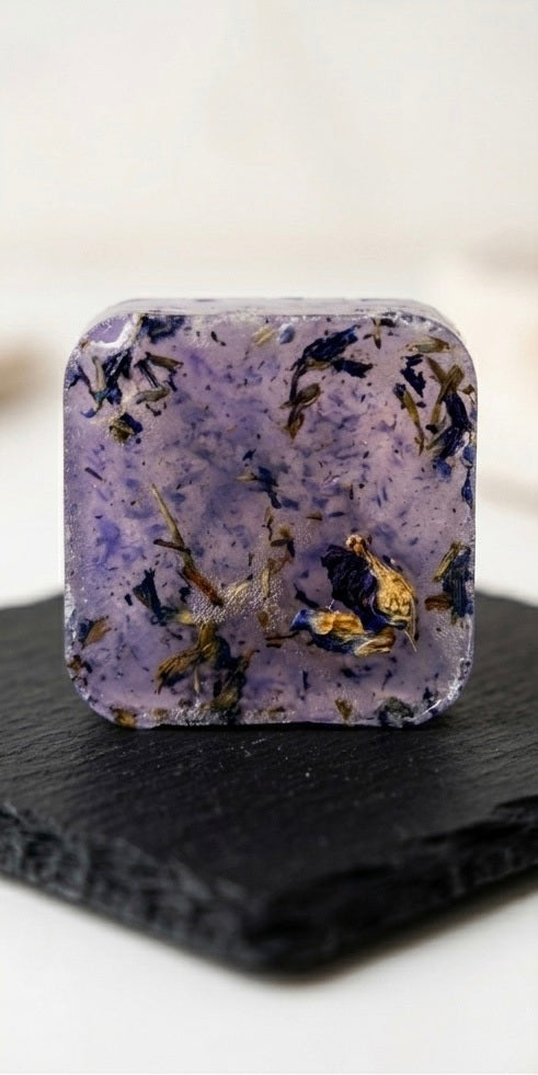 Herbes de Provence handcrafted botanical soap bar — purple with dried botanicals on a slate board
